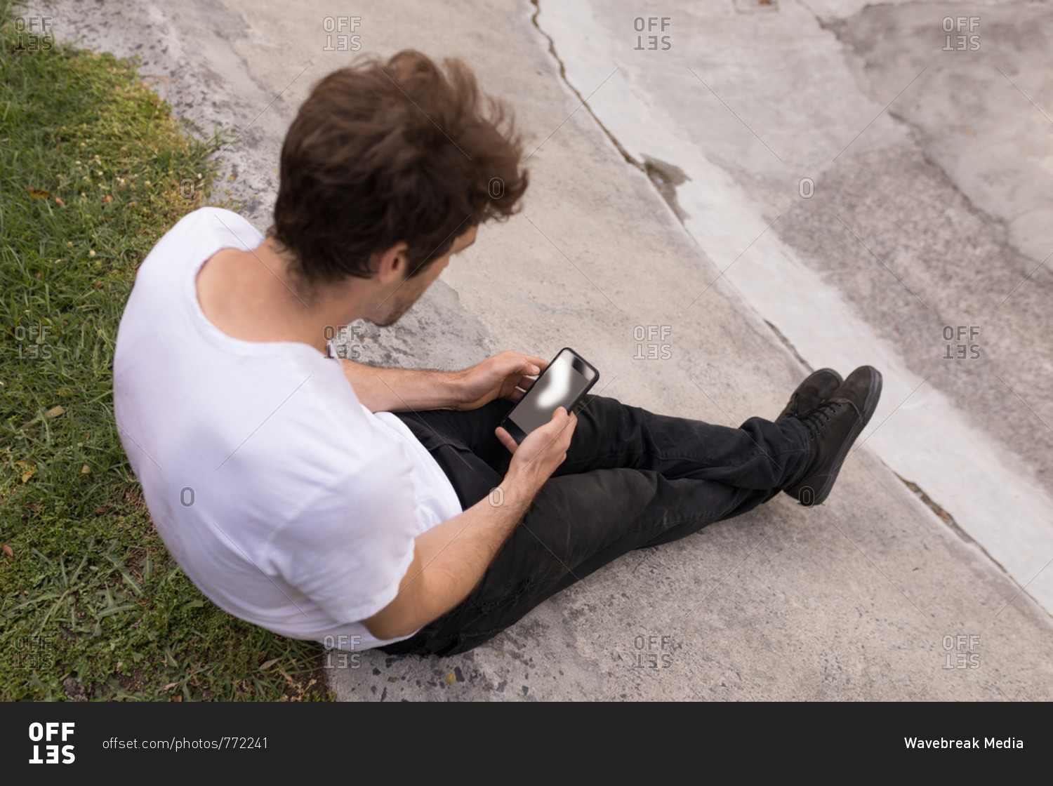 High angle view of man using mobile phone at skateboard park