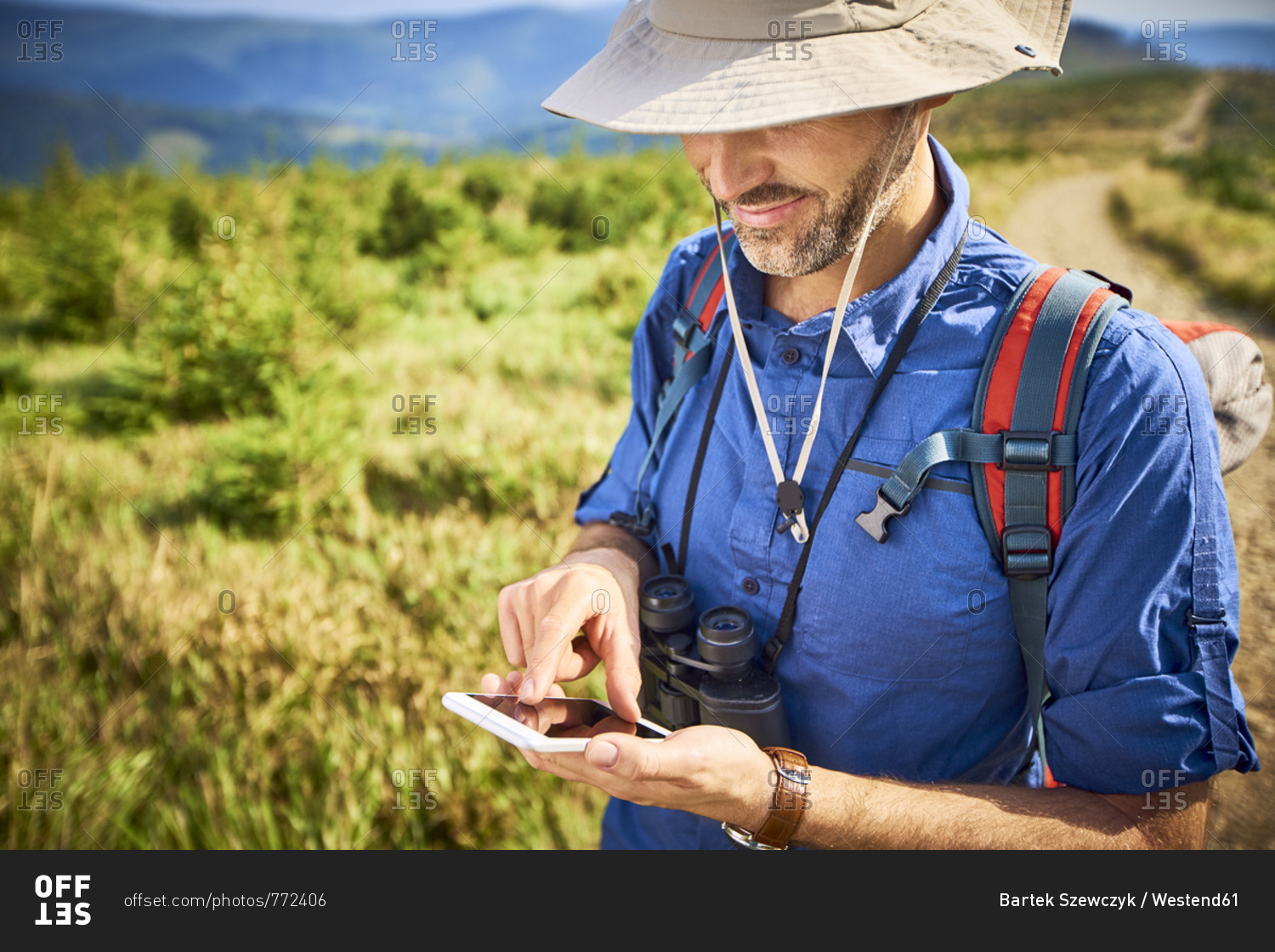 Man checking his cell phone during hiking trip