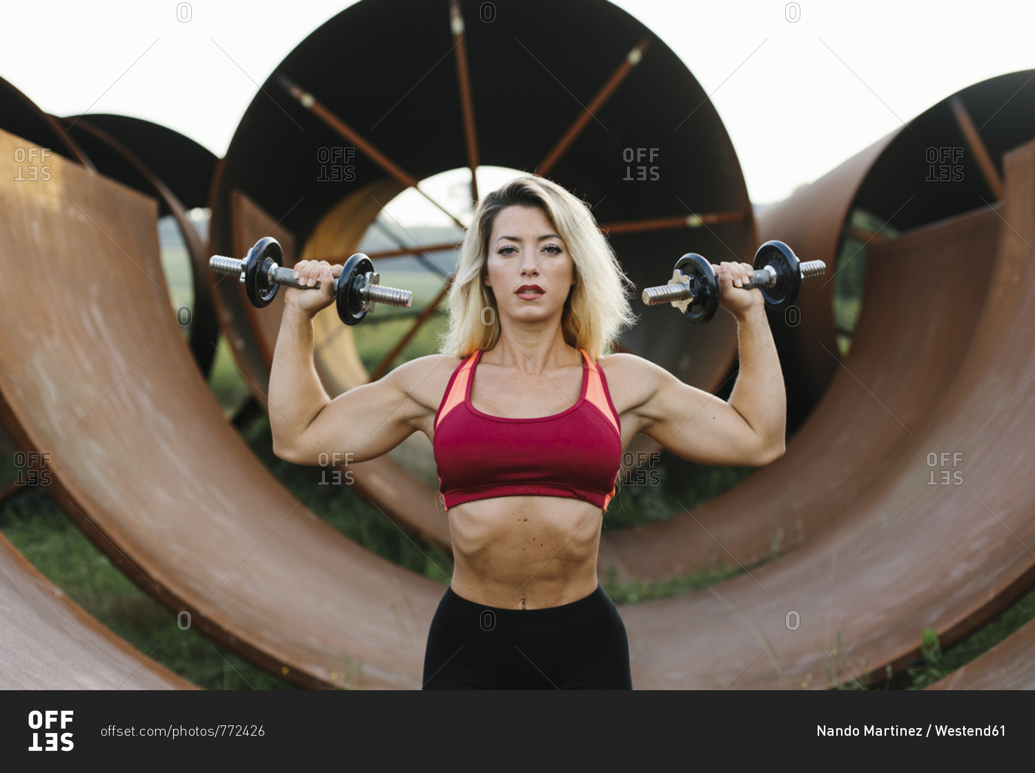 Athletic woman doing weight workout at industrial site