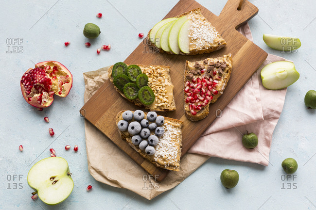 Bread slices with various toppings on wooden board