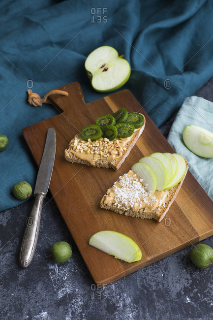 Bread slices with various toppings on wooden board