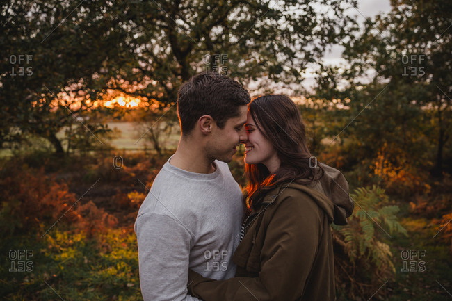 Happy couple in love in autumnal nature at sunset