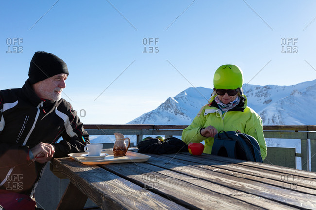 Senior couple interacting while having refreshment at winter bar