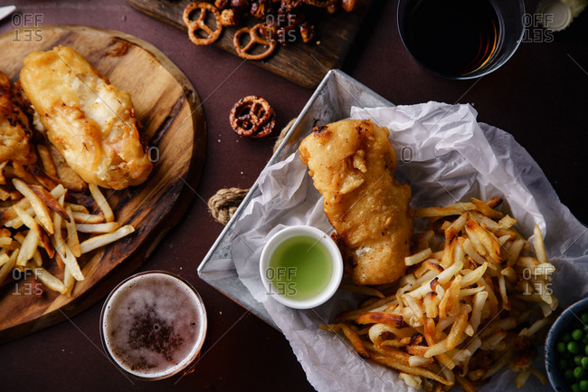 Overhead image of beer party with various snacks and fish-and-chips