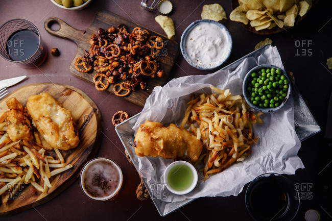 Overhead image of beer party with various snacks and fish-and-chips