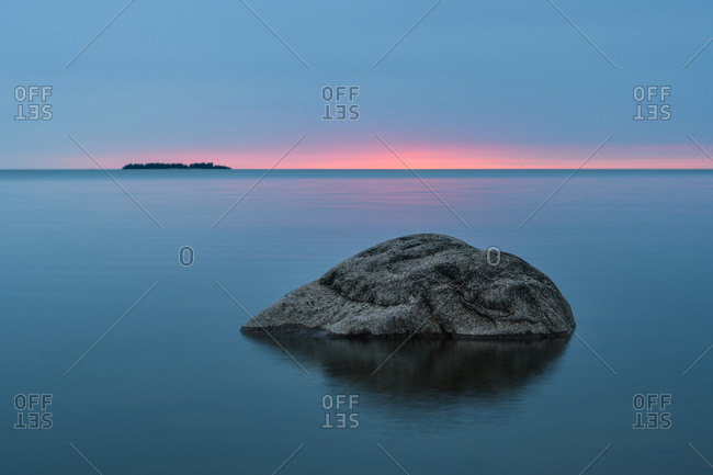 Rock formations by sea at dawn