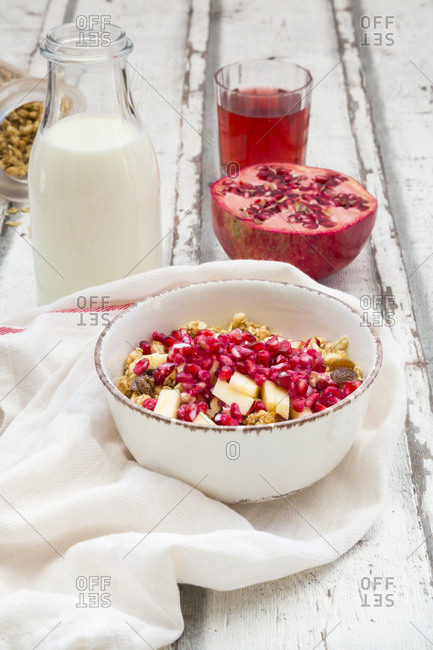 Breakfast with fruit muesli with pomegranate seed- bottle of milk and glass of pomegranate juice