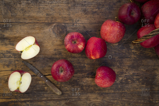 Red apples and knife on wood