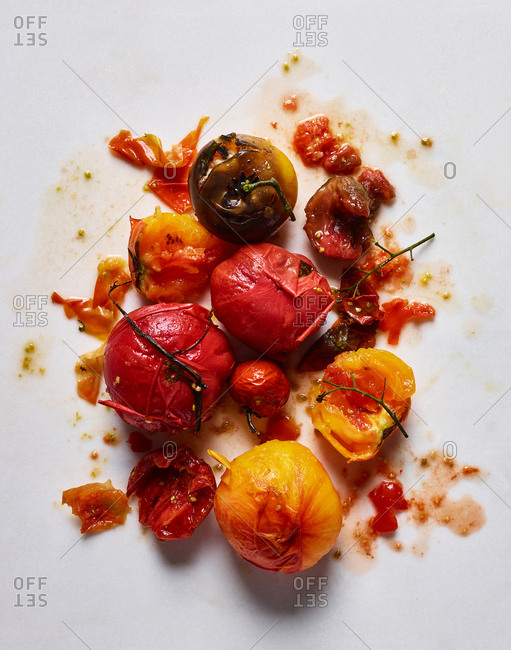 Red and yellow tomatoes on messy white background