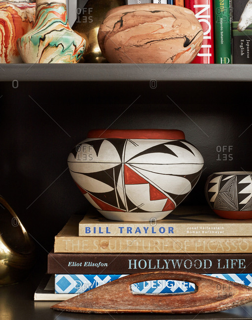 March 14, 2017 - Traditional Native American pots on top of a stack of books on a bookshelf