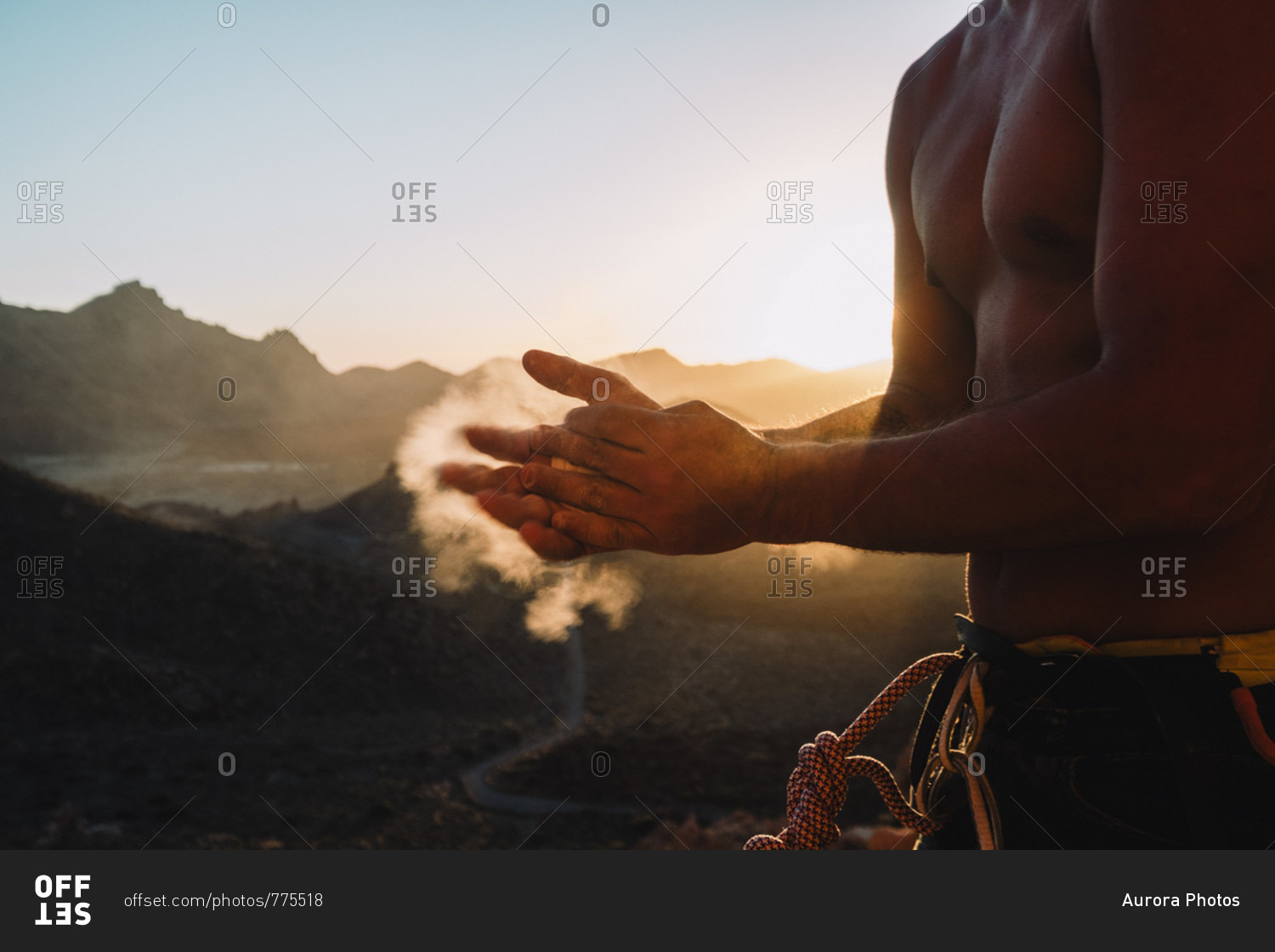 Mid section of shirtless climber standing outdoors at sunset and applying sports chalk, Tenerife, Canary Islands, Spain