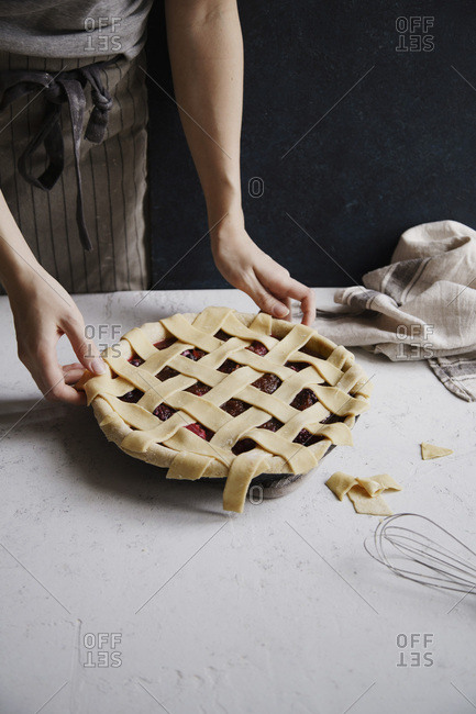Uncooked berry pie with a lattice decoration on top. Concrete background, cooking process.