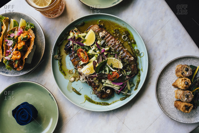 Ho Chi Minh City, Vietnam - August 1, 2018: Slow-cooked and char-grilled pork with Vietnamese herbs and spices, alongside foie gras spring rolls and banh xeo tacos at Anan Restaurant