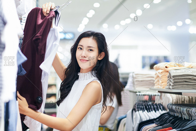 Young woman chooses clothes in a clothing store