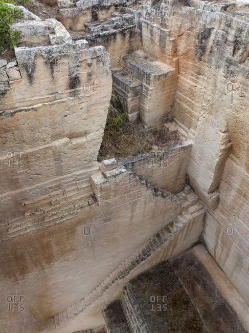 Drone view of narrow stairway near rocky wall in deep quarry on Menorca, Spain
