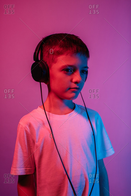 Cool boy with headphones listening music, colorful paints smudges