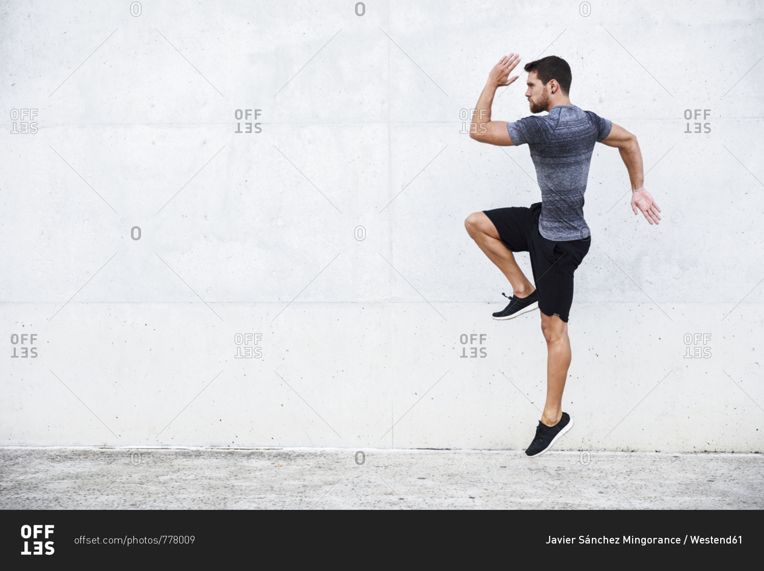 Athlete jumping in front of white wall