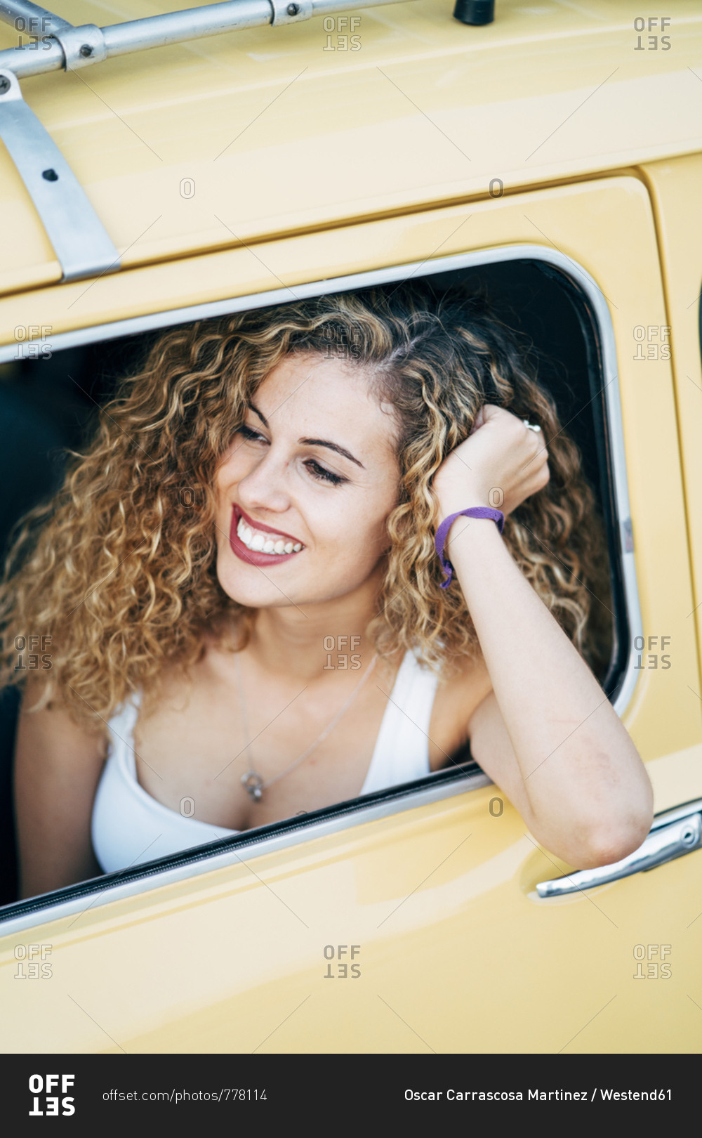 Smiling young woman looking out of car window