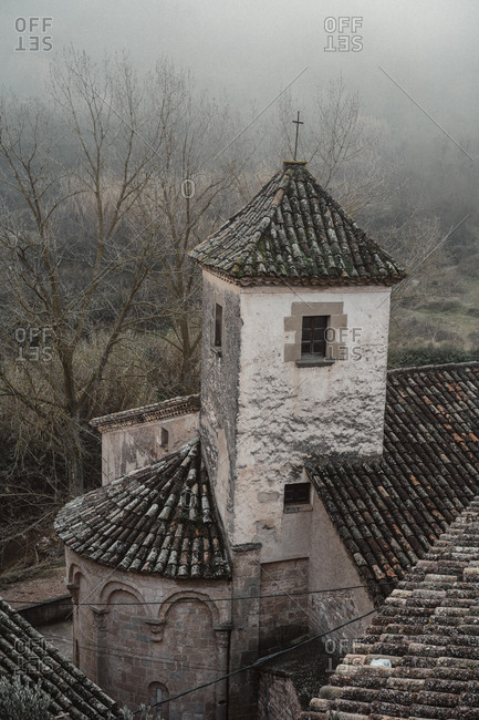 Old church in small village in foggy forest