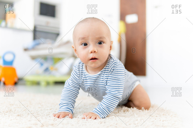 Baby boy crawling on fuzzy carpet
