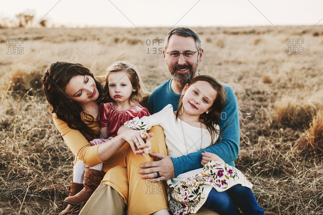A family of four embracing