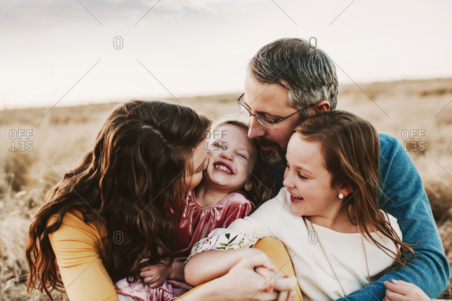 A family of four embracing