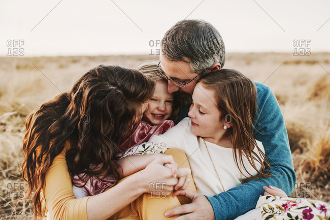 A family of four embracing