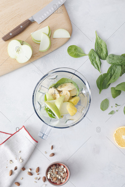 Fruit smoothie and ingredients on counter in a blender