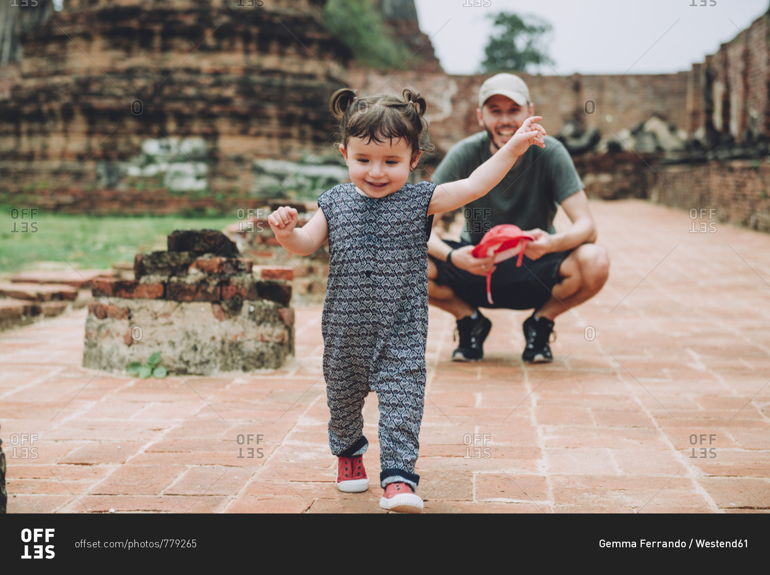 Thailand- Ayutthaya- Father observing his baby girl walking in the ancient ruins of a temple at Wat Mahathat