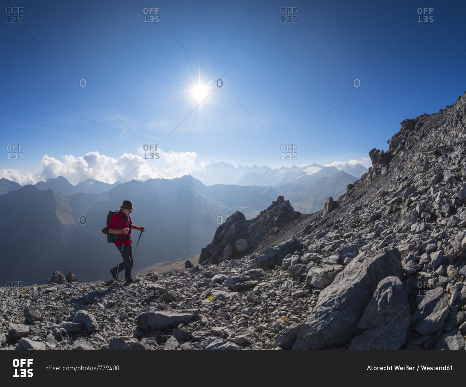 Border region Italy Switzerland- senior man hiking in mountain landscape at Piz Umbrail