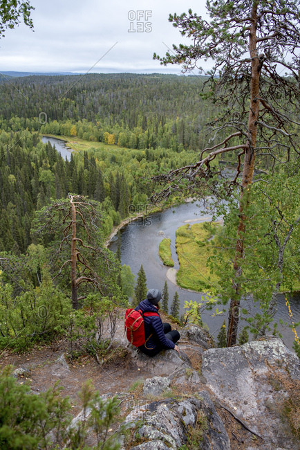 Finland- Oulanka National Park- woman with backpack sitting in pristine nature