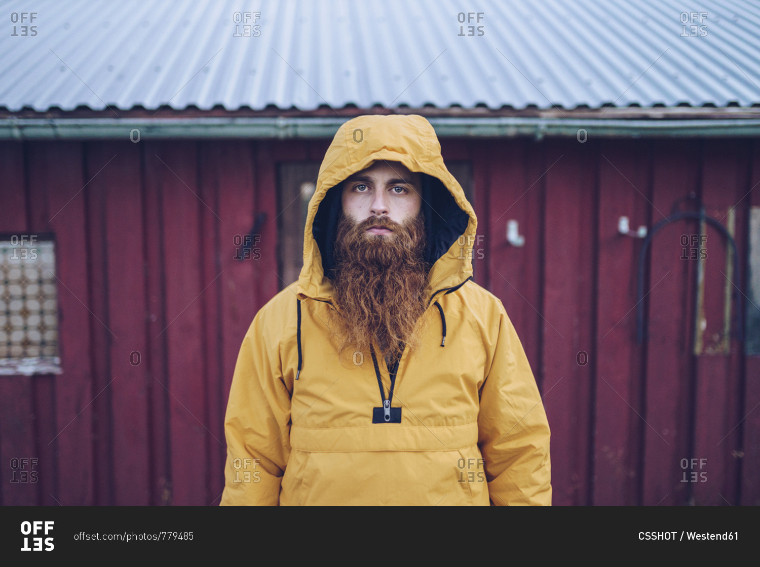 Sweden- Lapland- portrait of serious man with full beard wearing yellow ...