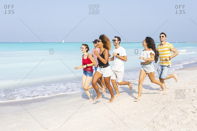 Friends having fun- running on the beach
