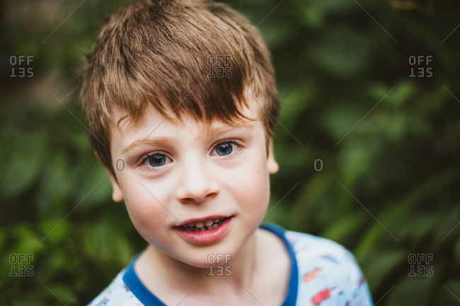 Portrait of a smiling boy with light brown hair and blue eyes stock photo -  OFFSET