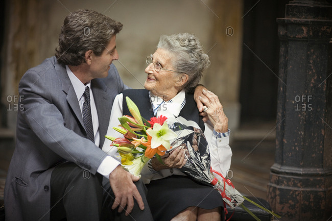 Side view of an aged woman with her son.