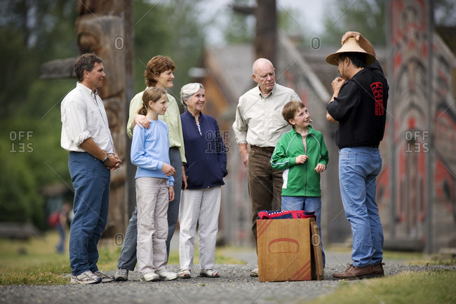 Native American man showing group of people his hat.