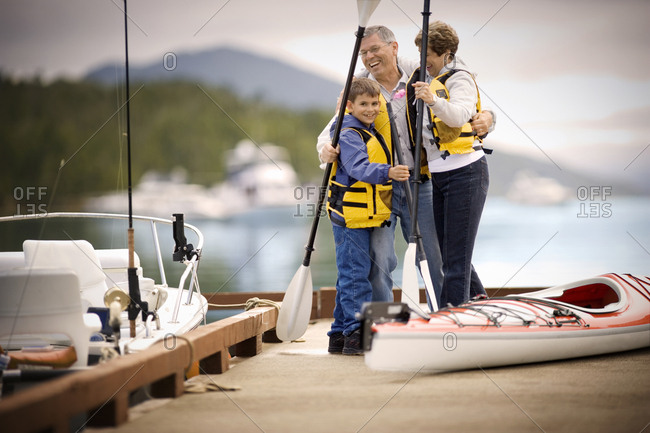 Young boy and his grandparents getting ready to go kayaking.