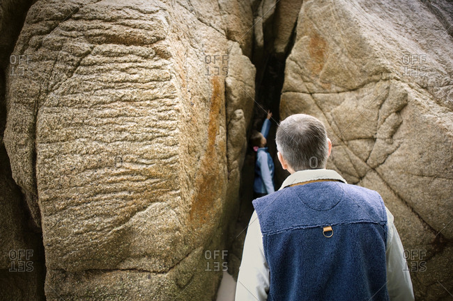 Young girl exploring the beach with her grandfather.