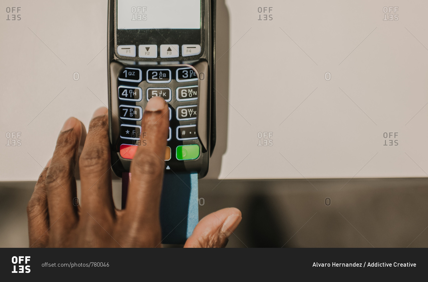 From above shot of hand of African American man pushing buttons on keypad of modern payment terminal
