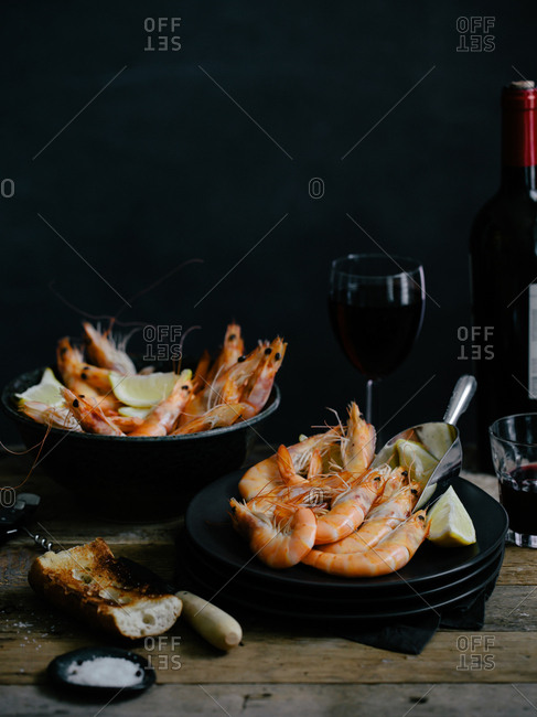 Bowls of boiled shrimp served with a toasted baguette