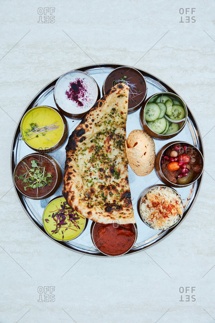Indian appetizer dish with flatbread and various dipping sauces