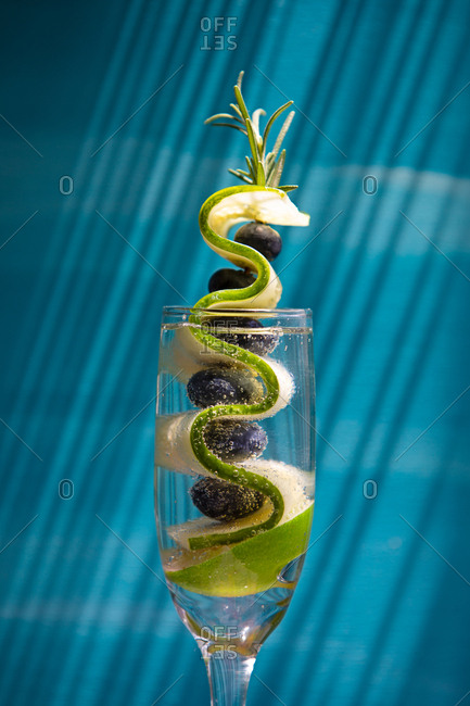 Tropical cocktail with cucumber and blueberry garnish
