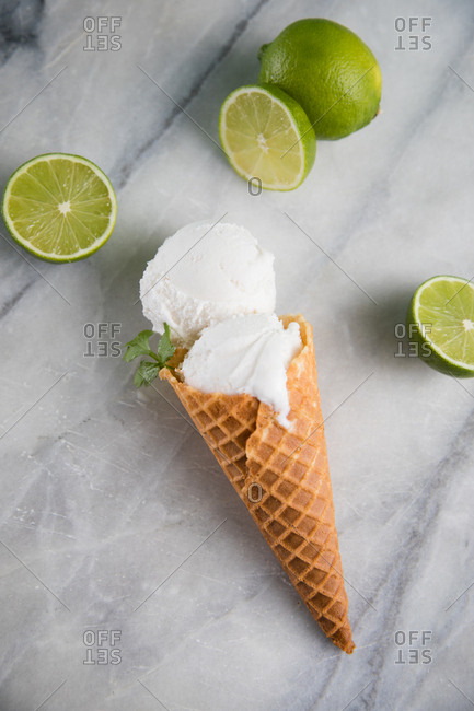 Cilantro lime ice cream in a cone on marble surface