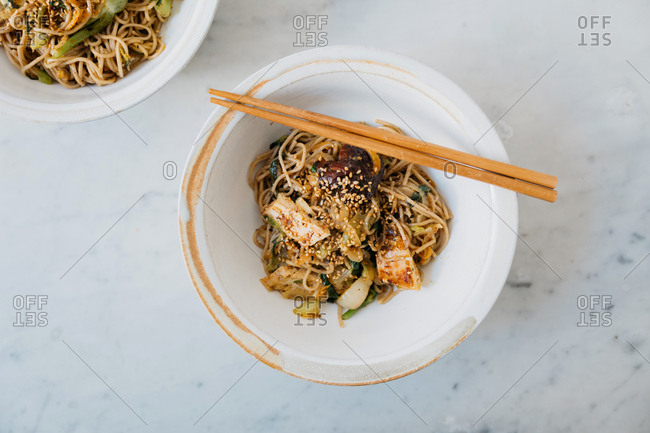 Soba noodle stir fry served in a bowl with chopsticks