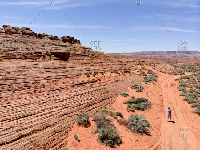 Tourist taking a photograph of red rock formations