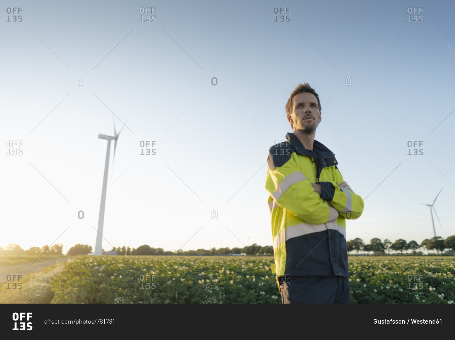 Engineer standing in a field at a wind turbine