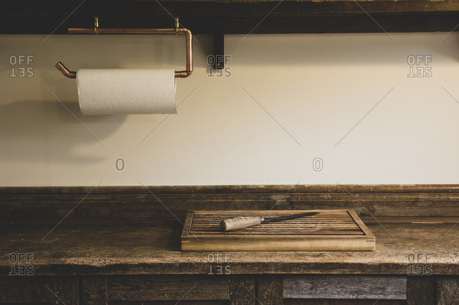 High angle view of wooden chopping board and knife on vintage wooden kitchen cupboard.