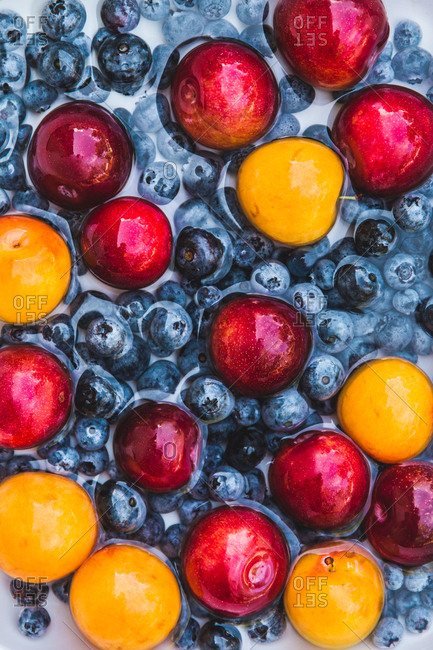 Blueberries and stone fruit being washed off before prepping