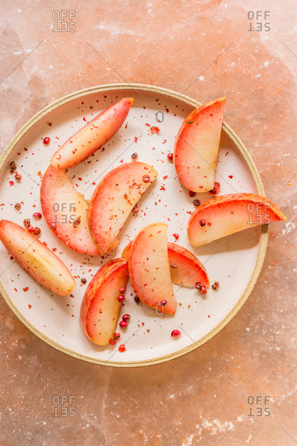 Pink stone fruit on pink plate on pink sea salt