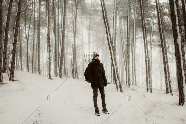 Person walking in fresh snow in a forest on a winter day